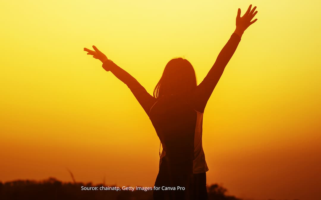 Person with arms in the air to illustrate changing the narrative behind impostor syndrome.