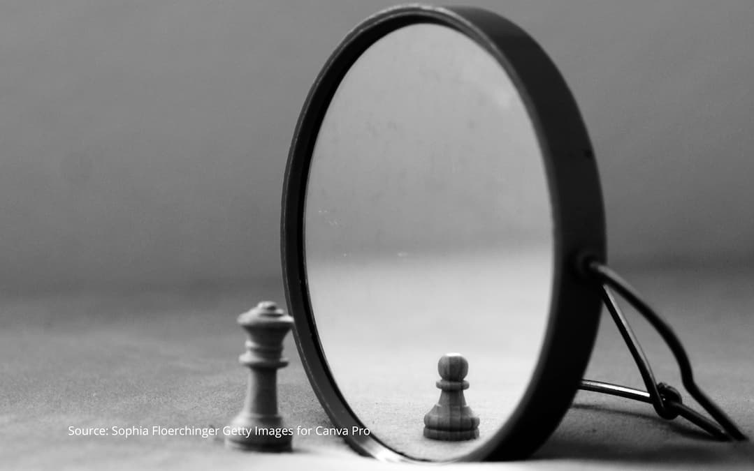 Chess pawn seeing smaller version of itself in a mirror to illustrate a cultural identity crisis.