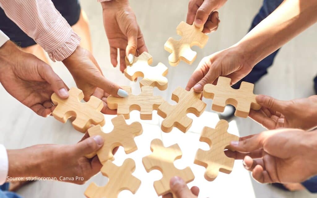 People holding puzzle pieces together to illustrate concept of a health organizational identity.