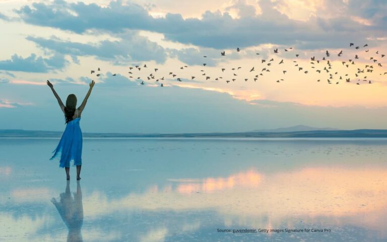 Person with arms in the air and birds flying overhead, illustrating how to let go of the past.